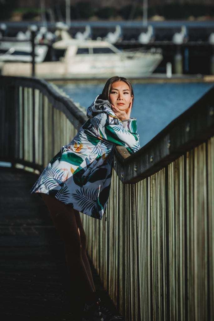 Scribbler rainwear, waterproof raincoat for women, rain jacket for ladies, outerwear, waterproof, mesh lined, lightweight, recycled plastic, sustainable fashion, winter coat, tropical Tropic print, mesh lined, beautiful, colourful print, breathable, packable coat, NZ, New Zealand designer, plus size, curvy, curves, white, green leaves, strelitzia, colourful rain jacket