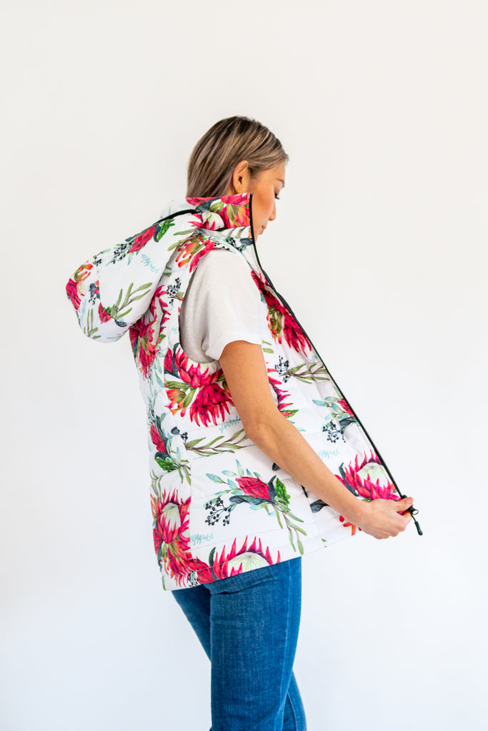 Scribbler protea vest, African protea print, White puffer vest, waterproof gilet, recycled fabric, recycled puffer, conscious fashion, plus size vest, floral vest, removable hood, botanical print, quilted vest, plus size vest, NZ, New Zealand, Australia, USA