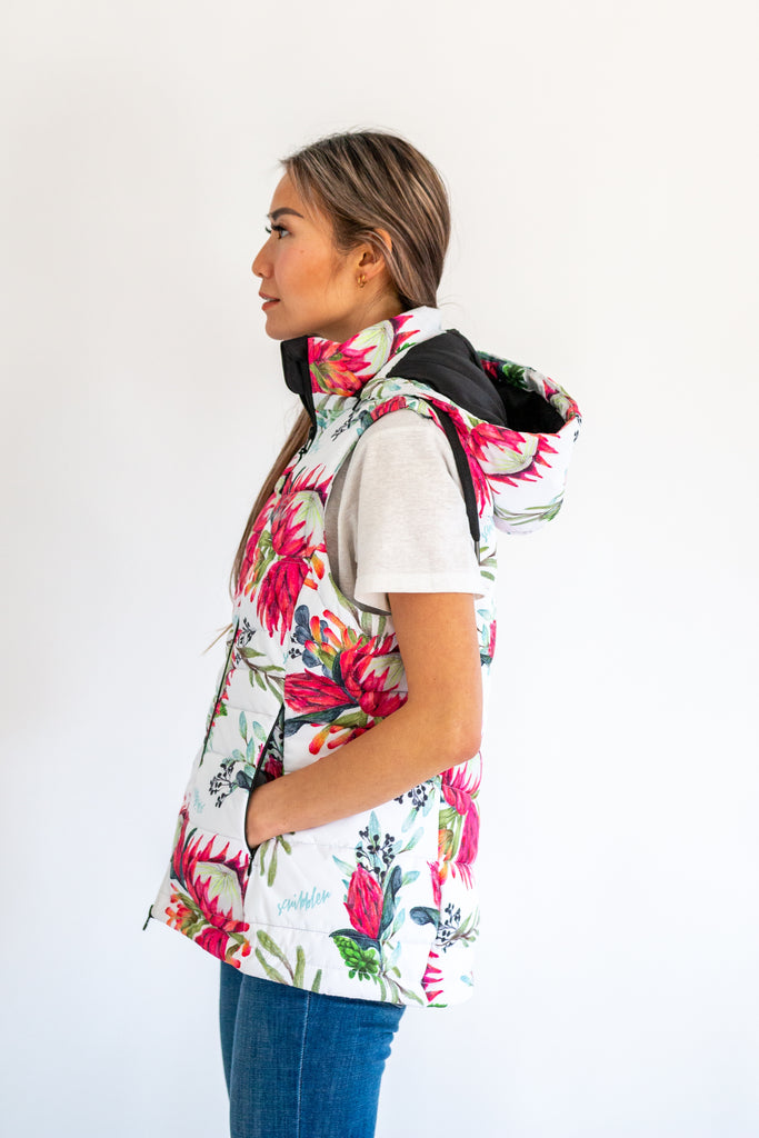 Scribbler protea vest, African protea print, White puffer vest, waterproof gilet, recycled fabric, recycled puffer, conscious fashion, plus size vest, floral vest, removable hood, botanical print, printed vest, colourful vest, quilted vest, plus size vest, NZ, New Zealand, Australia, USA