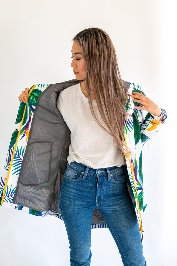 Scribbler rainwear, waterproof raincoat for women, rain jacket for ladies, outerwear, waterproof, mesh lined, lightweight, recycled plastic, sustainable fashion, winter coat, tropical Tropic print, mesh lined, beautiful, colourful print, breathable, packable coat, NZ, New Zealand designer, plus size, curvy, curves, white, green leaves, strelitzia, colourful rain jacket