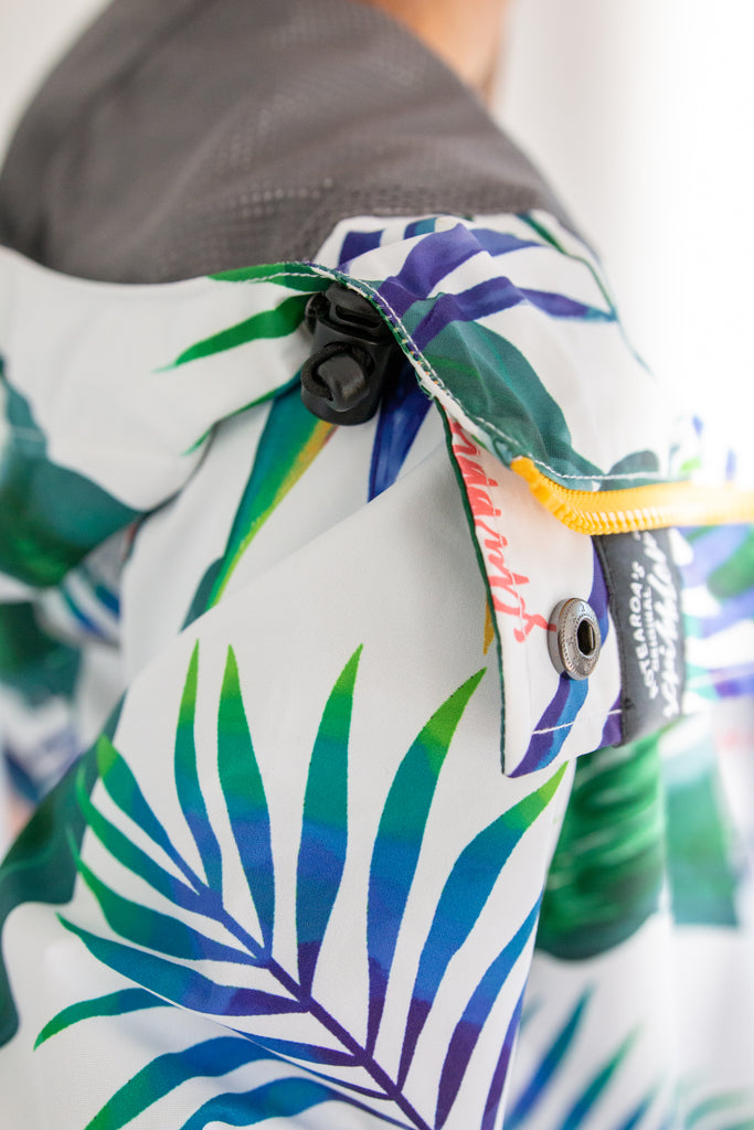 Scribbler rainwear, waterproof raincoat for women, rain jacket for ladies, outerwear, waterproof, mesh lined, lightweight, recycled plastic, sustainable fashion, winter coat, tropical Tropic print, mesh lined, beautiful, colourful print, breathable, packable coat, NZ, New Zealand designer, plus size, curvy, curves, white, green leaves, strelitzia, colourful rain jacket