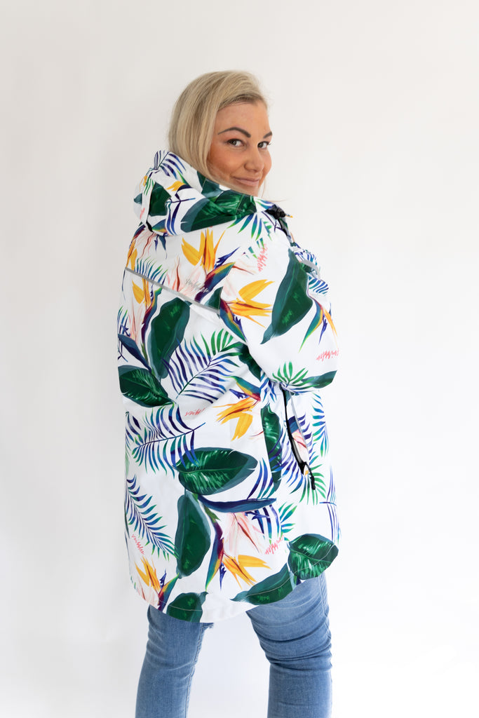 Scribbler rainwear, waterproof raincoat for women, rain jacket for ladies, outerwear, waterproof, mesh lined, lightweight, recycled plastic, sustainable fashion, winter coat, tropical Tropic print, mesh lined, beautiful, colourful print, breathable, packable coat, NZ, New Zealand designer, plus size, curvy, curves, white, green leaves, strelitzia, colourful rain jacket